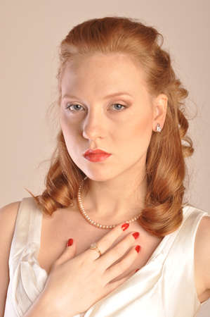 Portrait of red-haired girl with hair and beads of pearlsの写真素材