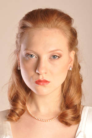 Portrait of red-haired girl with hair and beads of pearlsの写真素材