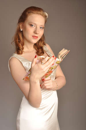 Portrait of red-haired girl with a book in their handsの写真素材