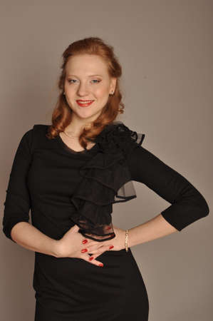 Portrait of a girl in a black dress on a gray backgroundの写真素材