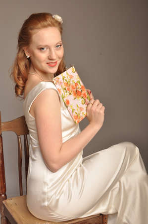 Red-haired girl with a book in her hand smilingの写真素材