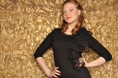 Portrait of a girl with red hair on a gold backgroundの写真素材
