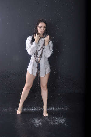 Woman wearing a white shirt barefoot in water to chain-handの写真素材