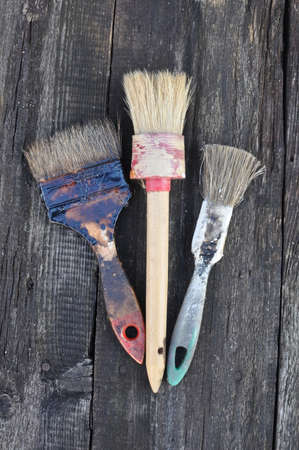 Paint brushes in paint on a wooden backgroundの写真素材