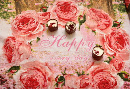Three chocolates on a pink tablecloth