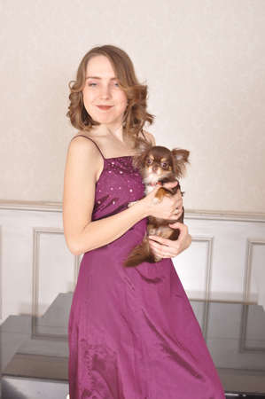 The girl in the purple dress with a small dog Chihuahua Chinese smilesの写真素材
