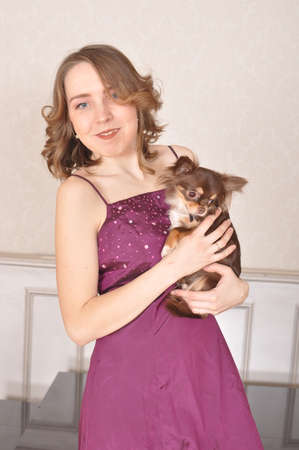 The girl in the purple dress with a small dog Chihuahua Chinese smilesの写真素材