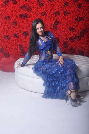 Girl in blue openwork dress on white sofaの写真素材