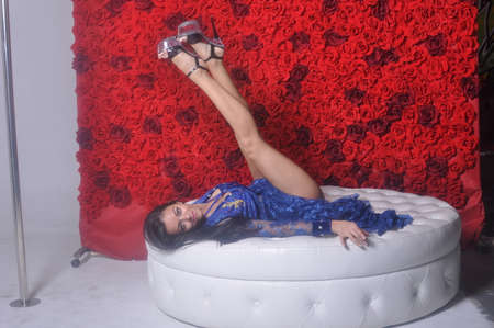Girl in blue openwork dress on white sofaの写真素材