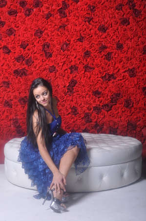 Girl in blue openwork dress sitting on white sofaの写真素材