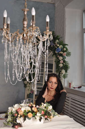 Girl sitting at the table with flowersの写真素材
