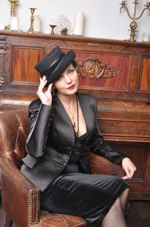 A girl in a black hat near the pianoforteの写真素材