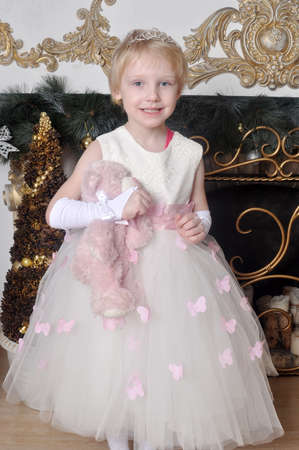 Little girl in a white dress with a toy in handsの写真素材