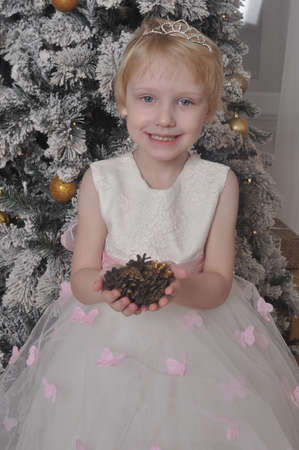 Little girl in white dress with cones in handsの写真素材