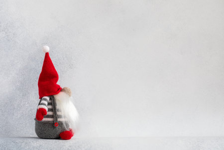 Christmas gnome in red hat side view holiday card on light winter backgroundの写真素材