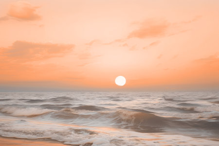 A serene summer beach with gentle waves under a soft peach fuzz color sunset. Modern trendy tone hue shadeの素材