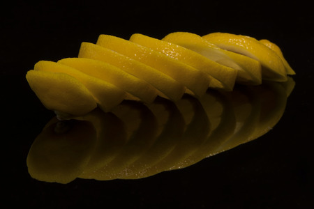 the lemon sliced on a black background with reflectionの写真素材