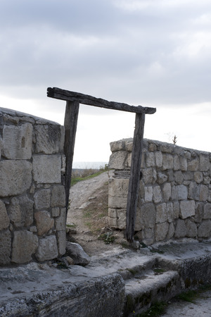 on the destroyed wall there is an arch of an old door with a footpathの写真素材