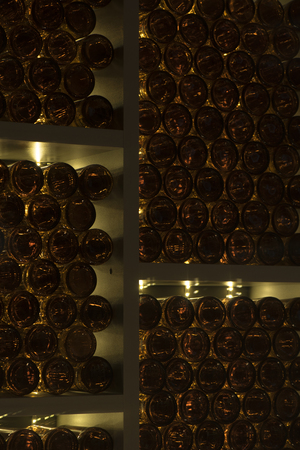 bottles of wine lie on shelves in a wine cellarの写真素材