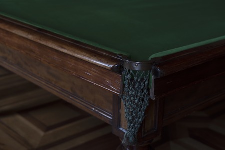 angle expensive billiard table corner pocket. pocket with mesh for the sword. the table is on the...