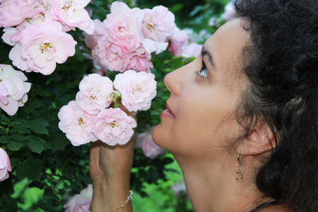 Close portrait of young girl with pink rosesの写真素材
