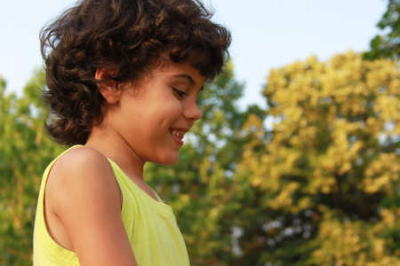 Close portrait of a curly little boy with charming dimples
