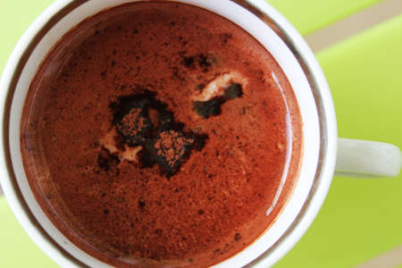 Cup of coffee on green table, isolated
