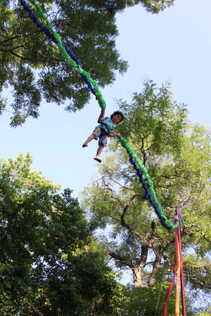Little boy enjoys bungee jumping high in the air