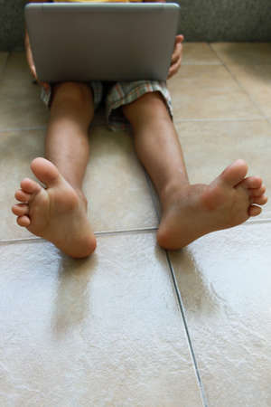 A boy with laptop sitting on the floor, isolated, no faceの写真素材