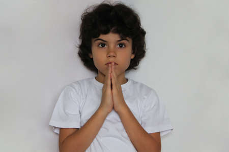 Studio portrait of a boy with hands together for supplicationの写真素材