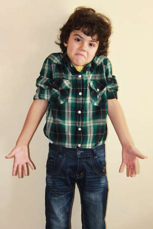 Studio portrait of an attractive boy with funny expressionの写真素材