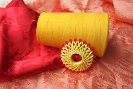 Closeup picture of yellow threads on colorful cloths