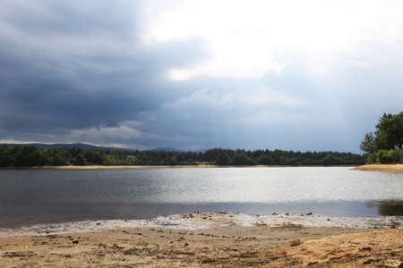 Picturesque landscape with beautiful lake near by green forestの写真素材