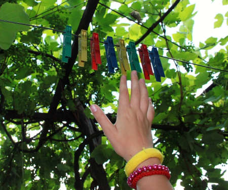 Abstract picture of colors with clothes pegs and children hand