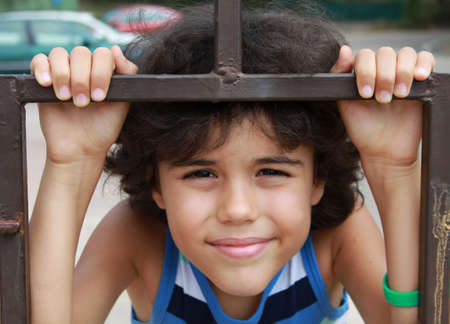 Outdoor portrait of beautiful boy with long curly hairの写真素材