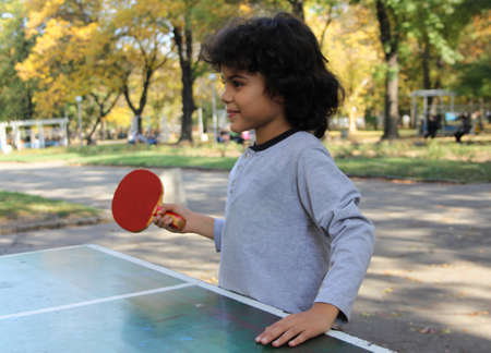 Cute little boy play table tennis in the parkの写真素材