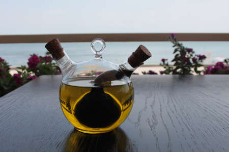 Closeup picture of a jar of olive oil on a wooden table