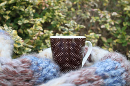 Closeup picture of a ceramic cup and an woolen scarfの写真素材