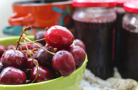 Closeup picture of a green bowl of fresh delicious red cherries