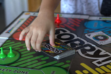 NC USA 1.24.2021 Child reaching for cards while playing popular board game Sorryのeditorial素材