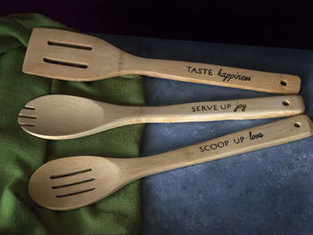 Three Wooden Spoons in a Kitchen with wording on the handlesの写真素材