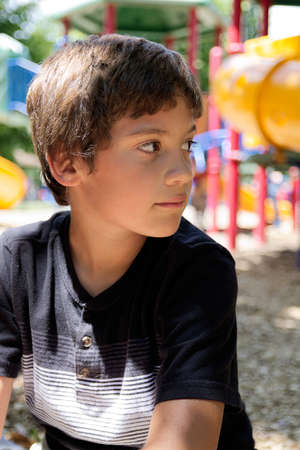 Young Boy Sitting at The Park. Close upの写真素材
