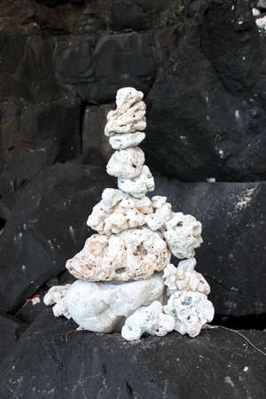 White coral rocks stacked on top of black volcanic rock on Kauai Hawaiiの写真素材