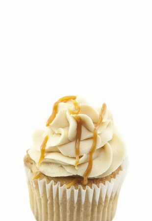 A delicious fresh baked caramel cupcake closeup with white backgroundの写真素材
