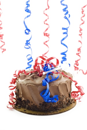A patriotic chocolate cake with red, white, and blue ribbons, on a vertical white backgound, selective focus with copy spaceの写真素材