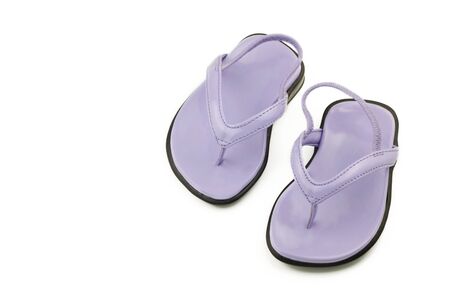 A tiny pair of newborn purple shoes or sandals for a girl, isolated on white with copy spaceの写真素材