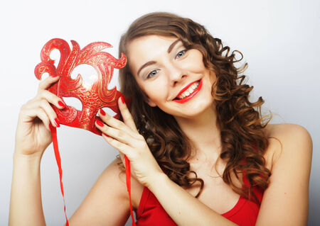 beautiful young woman holding red maskの写真素材