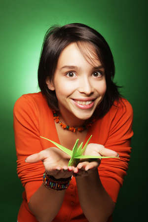 young expression woman with paper bird over green backgroundの写真素材