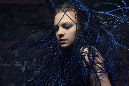Portrait of a stylish gothic woman with blue  dreadlocks.の写真素材
