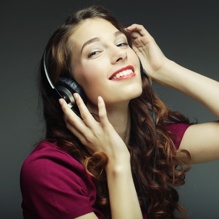 Young happy woman with headphones listening musicの写真素材